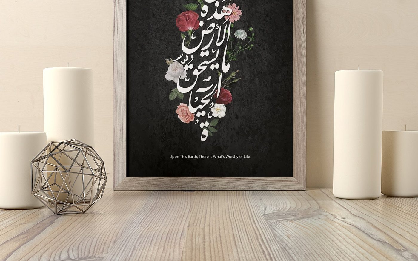 A framed print standing on a wood floor between candles and a wire sphere